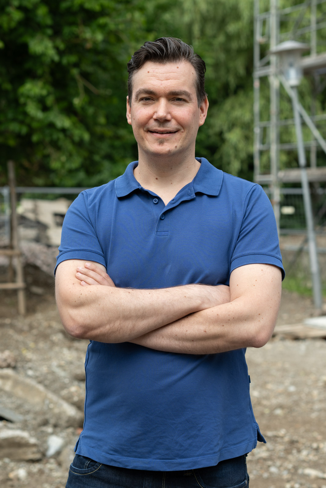Person in blauem Polohemd draußen.
