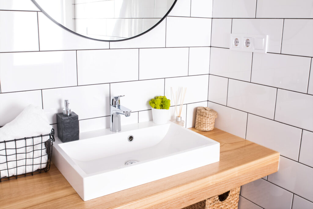 Waschbecken mit Utensilien und Spiegel.